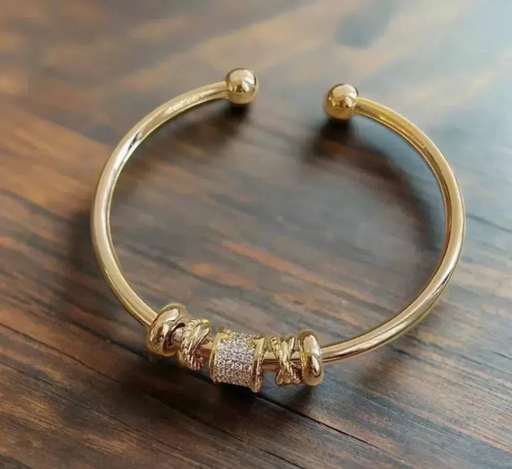 Adjustable bracelet featuring gold charms